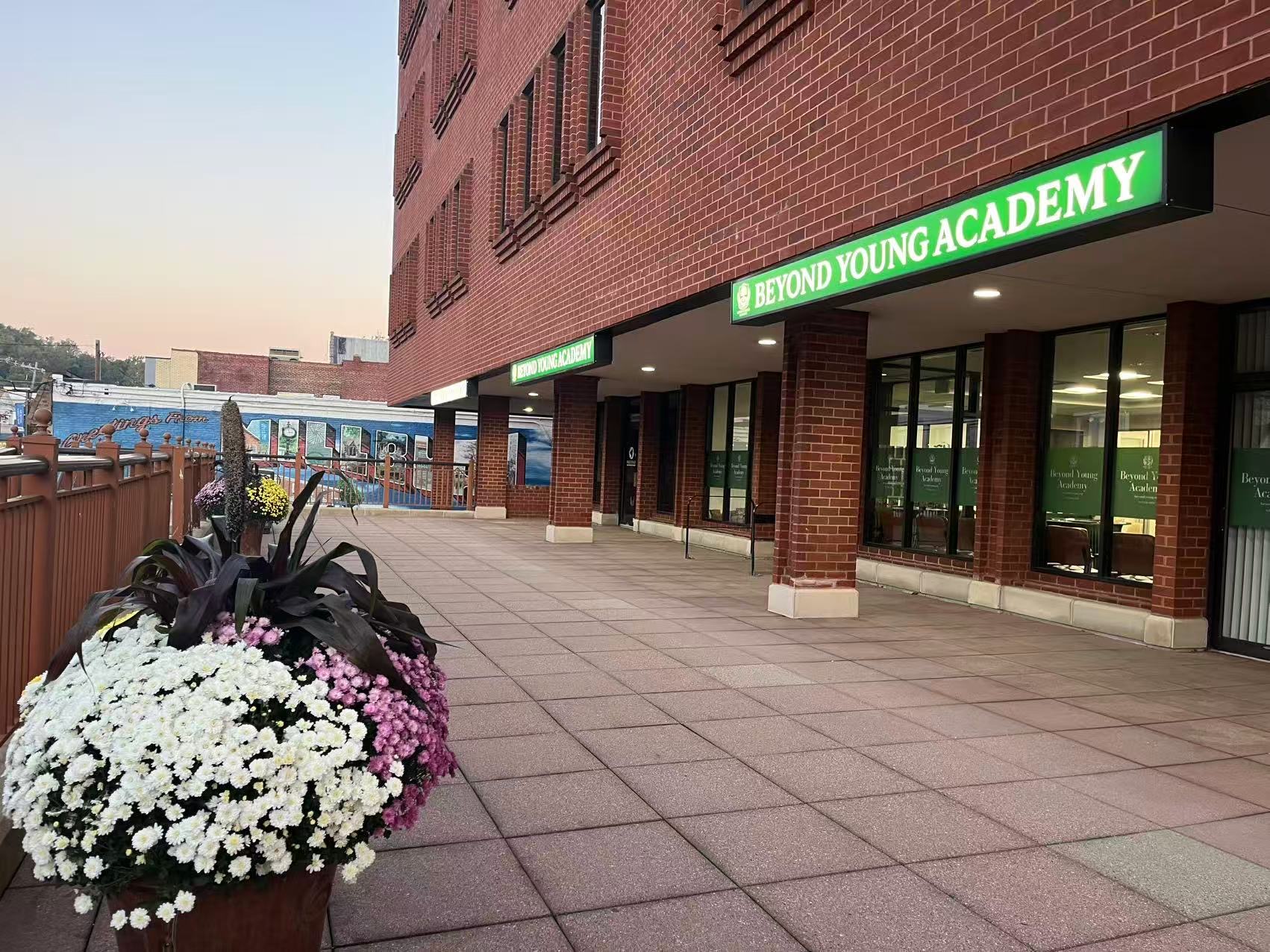 The Beyond Young Academy storefront at 374 Millburn Avenue, with the Greetings from Millburn mural across the street